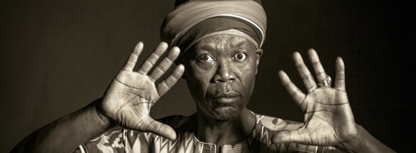 African man in traditional clothes toothy smile, on grey background