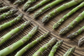 Fresh raw garden asparagus on rustic wooden table background