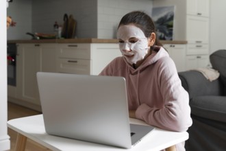 Young woman with beauty mask at home. Snackable wellness concept. Self care for home office . Quick