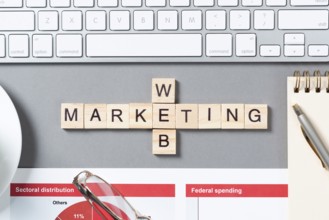 Web marketing concept with letters on cubes. Still life of office workplace with crossword. Flat