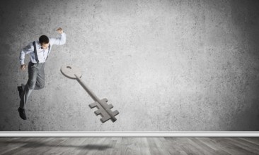 Determined businessman in empty interior breaking with fist stone key figure