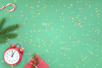 New Year or Christmas pattern flat lay top view with red alarm clock twelve midnight fir tree
