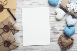 Flat lay cute composition with handmade fabric heart. White paper and retro mail envelopes on
