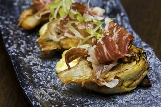 Roasted artichoke hearts with slices of raw ham, jamon de bellota