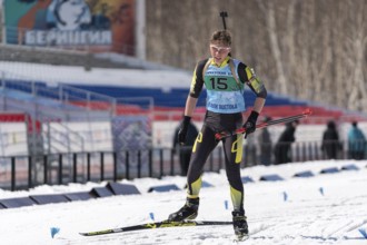 Sportsman biathlete Khanzutin Artem skiing on ski track distance biathlon stadium during Junior