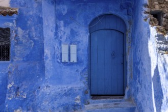 Vibrant blue colored wooden door in downtown Chefchaouen, Morocco, Africa