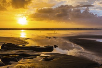 Concept of active and ecological tourism. Stunning sunset on the beach near Auckland. Coast of the