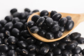A lot of black soybeans on wooden background