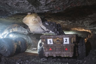 The loader pours copper ore on a truck in the mine