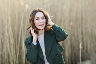 Portrait of a beautiful middle-aged woman posing at sunset