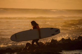 Single surfer at sunset on a calm ocean