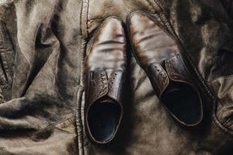 Brown leather shoes paired with a leather jacket, enhancing a vintage and rustic feel