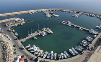 Drone aerial scenery of a fishing port. Fishing boats and yachts moored in the harbour. Zygi marina