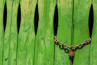 Green door in the stone wall with lock locked in Cala Figuera Mallorca Spain