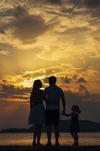 Silhouette of a family with children against the backdrop of the setting sun and sea in Montenegro