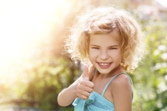 Portrait of a smiling little girl showing thumbs up