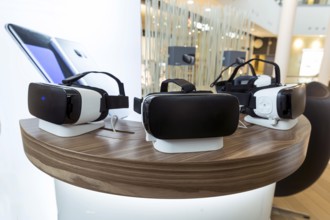 Virtual reality (VR) headsets (glasses) on a table. VR is immersive multimedia or