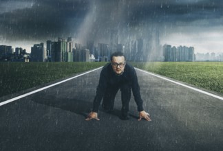 Young businessman starting position to his career with city skyline background, raining day .