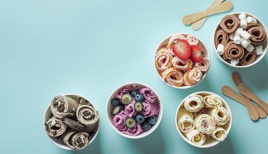 Rolled ice creams in cone cups on blue background. Different iced rolls top view or flat lay. Thai