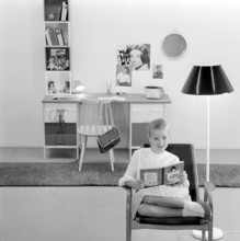 In the 1960s. A teenage girl in her typical 1960s room, a desk and her things with pictures of her