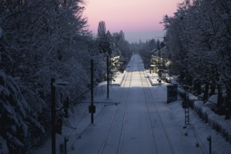 Railway tracks and surroundings covered with snow under winter sun, Allensbach, Lake Constance,