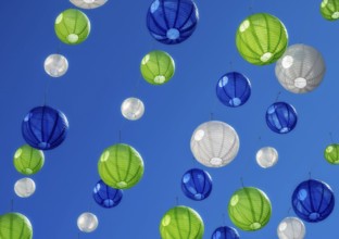 Party with colourful lampions hanging under a blue sky