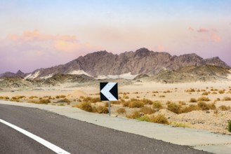 Sign on road in the desert of Egypt at sunset