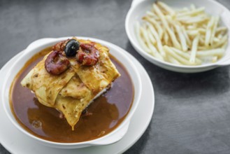 Famous francesinha traditional meat cheese and spicy sauce grilled sandwich of porto portugal