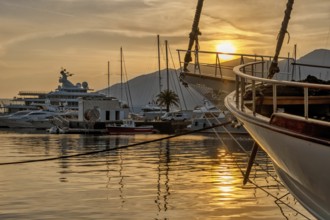 View of Harbor and marina with moored yachts and motorboats at sunset