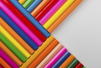 Abstract composition of a set wooden colour pencils against a white background
