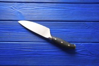 Chef tools black knife on a blue wooden background