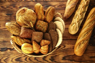 Bread fresh varied mix on golden rustic wood in basket