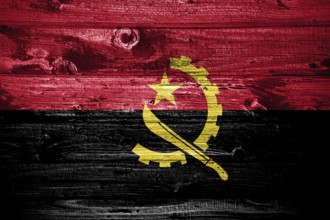 Angola flag on wooden planks background wood flag