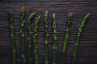 Asparagus raw vegetables in a row on aged wood background