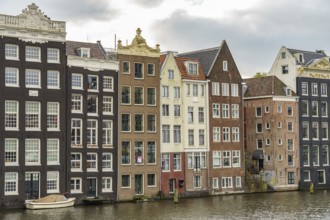 Traditional buildings on the canal bank with clouds drifting above, Amsterdam, Netherlands