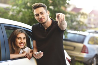 Beautiful girl sitting in the car and flirting with guy who outdoor standing