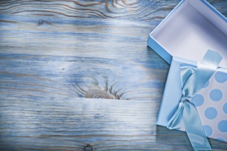 Blue opened gift box on wooden board copy space holidays concept