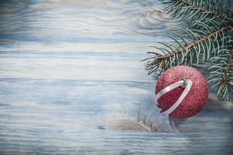 Fir branch red Christmas ball on wooden board celebrations concept