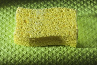 New yellow sponge on green washcloth