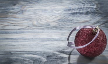Red Christmas round toy on wooden board holidays concept