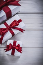 Present boxes with tied bows on wooden board holidays concept