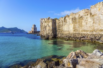 The watchtower is built on long cape in the sea. Sea shoal beautiful azure color. Venetian fort