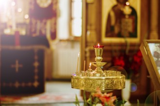 A church interior with a brass candle holder featuring lit candles