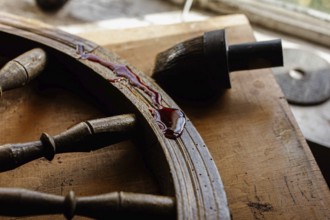 Red epoxy and brush on a workbench with wooden elements, crafting tools visible