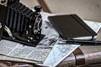 Still life with an old camera, pen, glasses and a road map in vintage style. Memories from