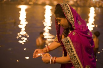 Woman offering oil lamp to godavari river, Nasik, maharashtra, india, asia