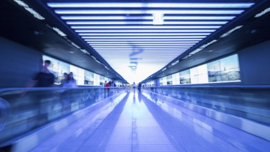 People going in walkway and riding flat escalators at the airport of Seoul, South Korea. Futuristic