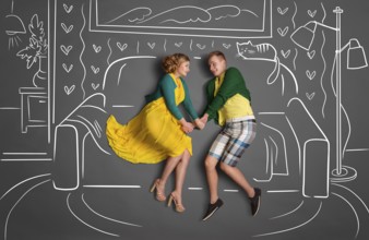 Happy valentines love story concept of a romantic couple sitting on a sofa and holding hands