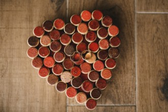 Wedding rings of the bride and groom on a pattern of hearts made of wine bottle corks on a wooden