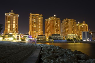The skyline panorama of The Pearl-Qatar area buildings in Doha, Qatar at night. The Pearl-Qatar is